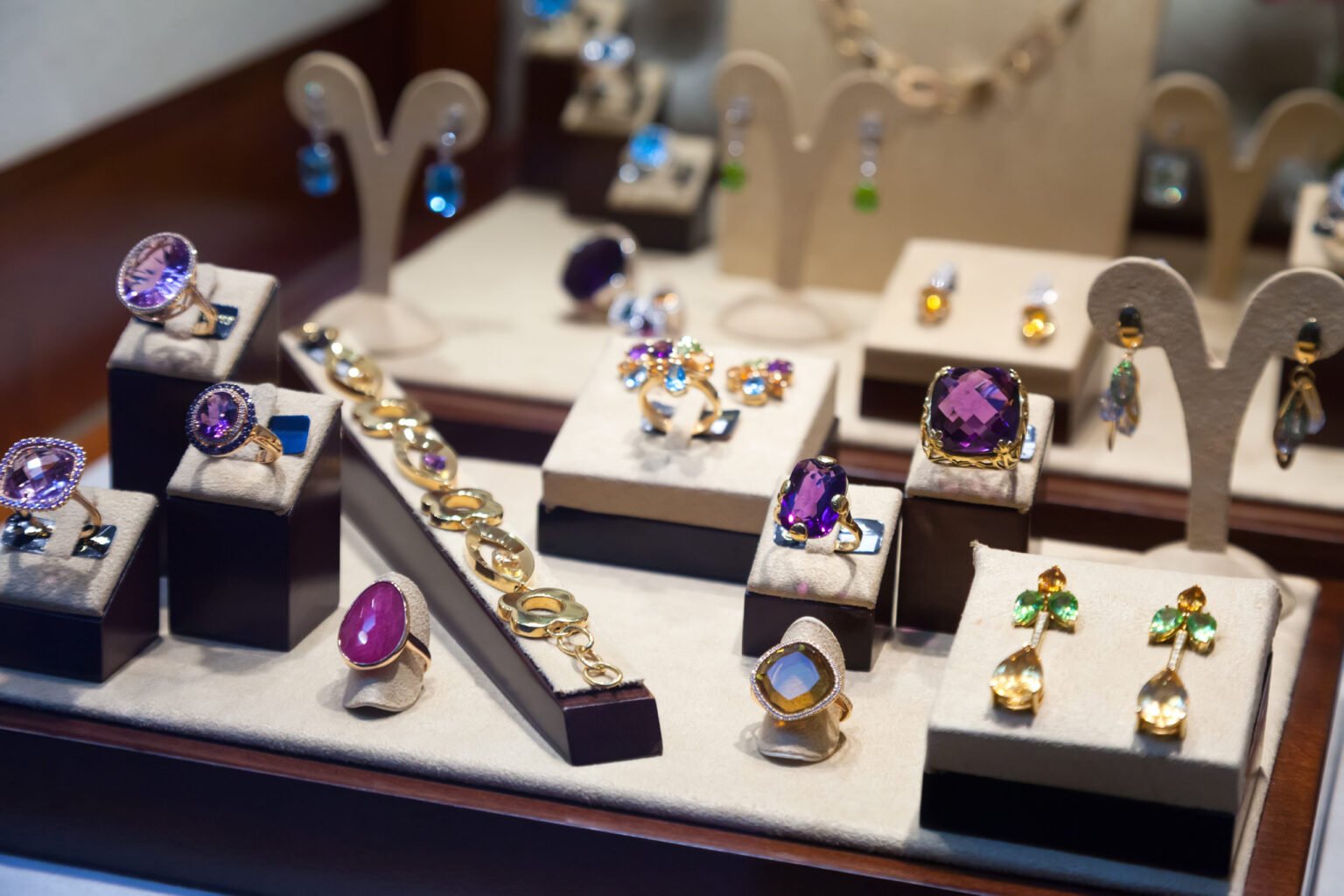 An assortment of precious antique jewelry, including rings and brooches, laid out on a dark surface, highlighting the need for specialized transit insurance.